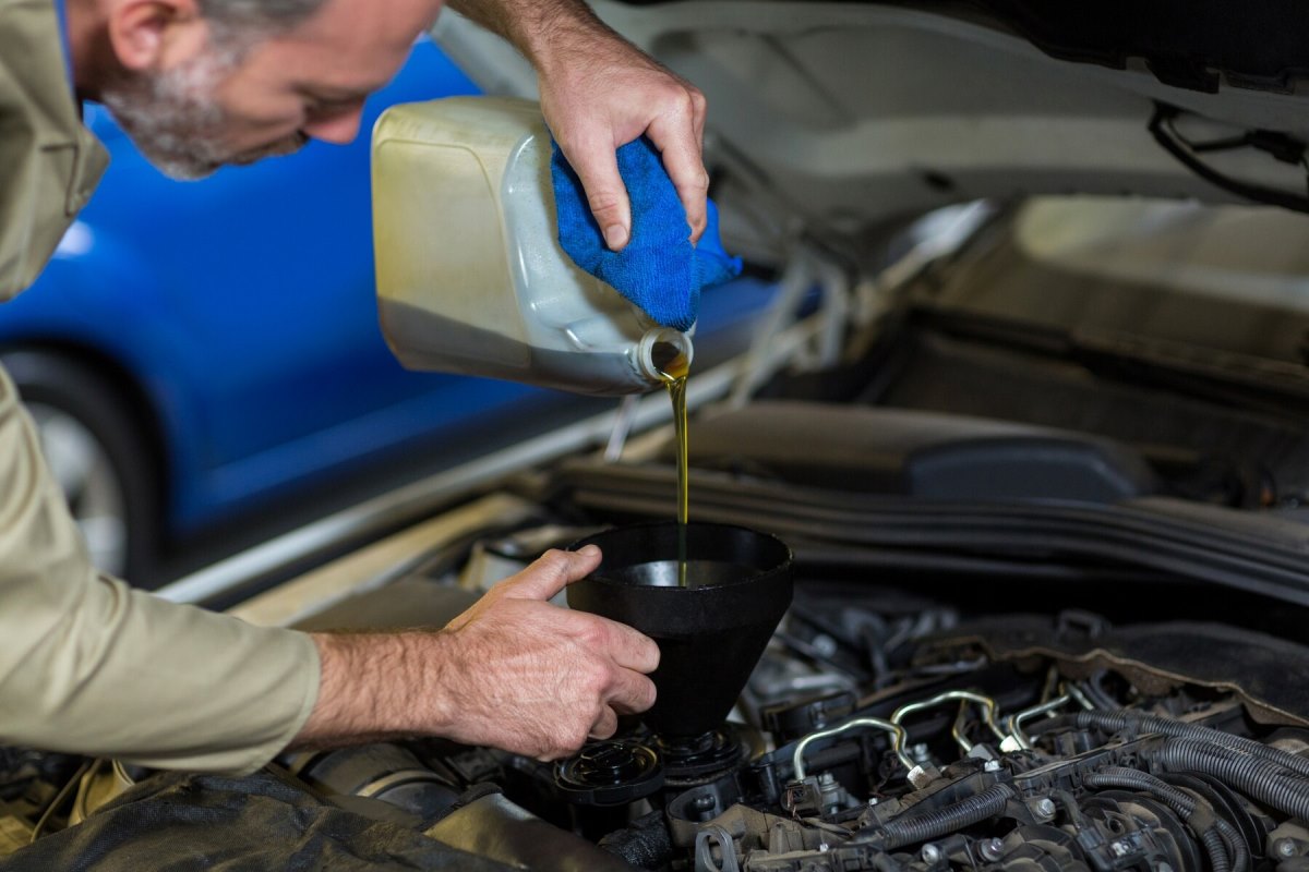 mechanic-pouring-oil-into-car-engine_1170-1308.jpg